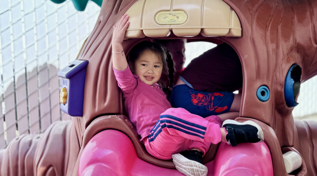 A young girl plays on play equipment at preschool in napa