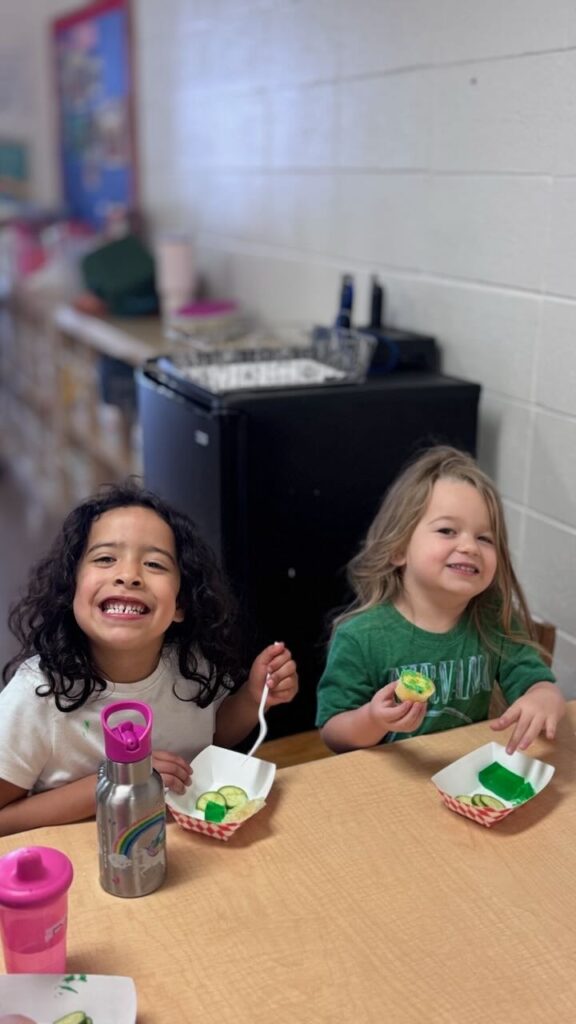 Children smile while eating their preschool snack