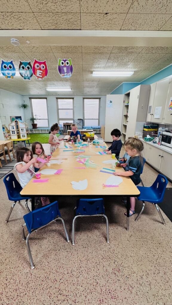 students sitting at a table in a small-class preschool classroom in napa