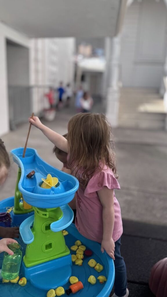 A preschool child plays at a water table in napa
